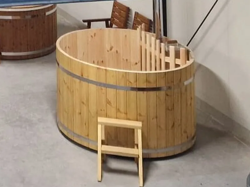 Grenenhouten hottub met rvs banden en trapje in de showroom