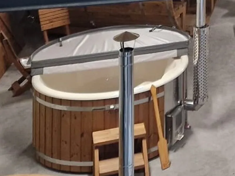 Hybride hottub met witte kuip, houten ombouw en interne kachel in de showroom
